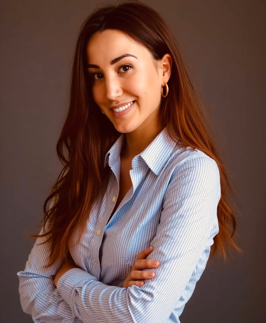 Jessica smiling with her arms crossed, wearing a blue shirt.